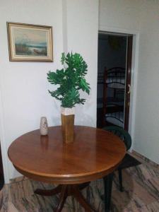 a wooden table with a plant on top of it at Vacations in Patra Rooms in Patra