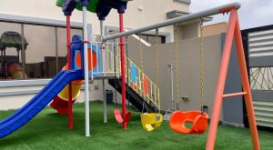 un parque infantil con tobogán y columpios en Al Jabal Resort Villa 2 en Salalah