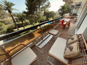 een balkon met stoelen en tafels en uitzicht op de oceaan bij La Paisible in Saint-Raphaël