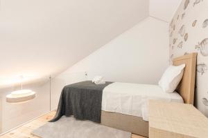 een witte slaapkamer met een bed en een stoel bij CATCH - Vilamoura in Vilamoura