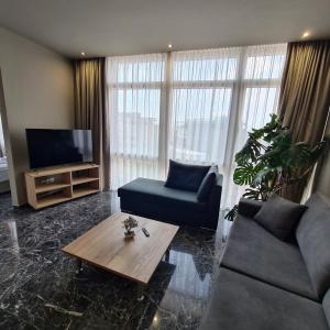 uma sala de estar com um sofá, uma televisão e uma mesa em Ladadika 5th Floor em Tessalônica