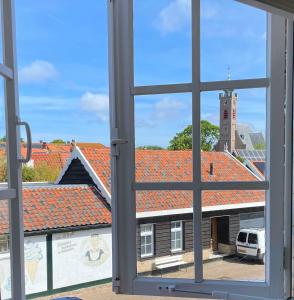 a view from a window of a building with red roofs at HOTEL bij de BAKKER in Burgh Haamstede