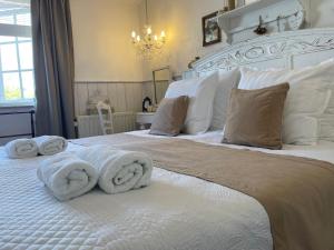 a bedroom with a white bed with towels on it at HOTEL bij de BAKKER in Burgh Haamstede