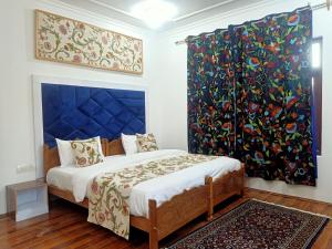 una camera da letto con un letto con testiera blu di The Light House a Srinagar