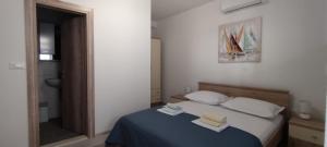 een slaapkamer met een bed met twee handdoeken erop bij Studio apartman Ana in Makarska