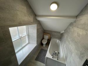 a bathroom with a bath tub and a toilet at The Bala House in Bala