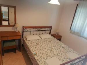 a bedroom with a bed and a table and a mirror at Porto Almira Beachfront Apartrments in Nikiti