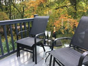 two chairs and a bottle of wine on a deck at P23 - Studio Pod with Hot Tub in Bethesda