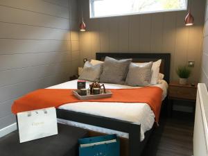 a bedroom with a bed with an orange blanket at P23 - Studio Pod with Hot Tub in Bethesda