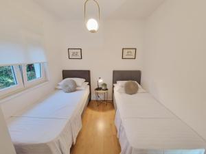 2 łóżka w pokoju z białymi ścianami w obiekcie Kuća za odmor Sika w mieście Sinj