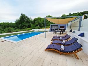 um pátio com espreguiçadeiras e uma piscina em Kuća za odmor Sika em Sinj