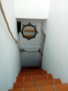 a stairway with orange tiles and a sign on the wall at El Escondite de Vejer in Vejer de la Frontera
