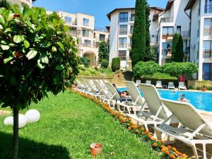 a row of chaise lounge chairs next to a swimming pool at La terrace Sea view in Sveti Vlas