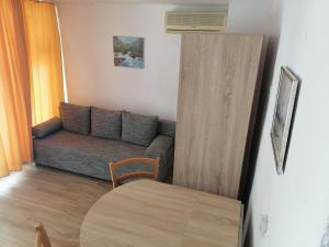 uma sala de estar com um sofá e uma mesa em Apartman Milica em Golubić