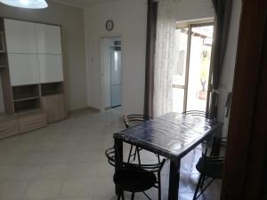 a dining room with a black table and chairs at Casa vacanze in Massafra