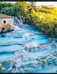 a view of a blue river with a waterfall at Il Poggio da Katia in Saturnia