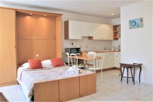 a bedroom with a bed and a table and a kitchen at Viva Riviera 6 Rue Commandant André in Cannes