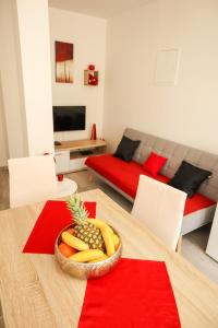 a living room with a table with a bowl of fruit on it at Apartments Silva in Split