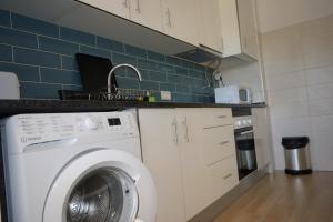 a kitchen with a washing machine in a kitchen at Apartamento Azul in Quarteira