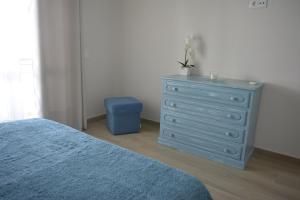 a bedroom with a blue dresser and a blue stool at Apartamento Azul in Quarteira