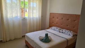 a small bed with a green frog sitting on it at Asilah Marina Golf Appart in Asilah +21 photos