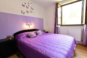 a purple bedroom with a bed with a purple comforter at Apartment Mlađen in Rastovača