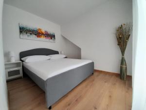 ein Schlafzimmer mit einem Bett und einer Vase aus Blumen in der Unterkunft Apartment Karlito in Omiš