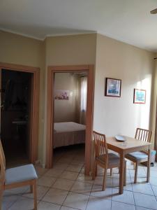 ランペドゥーザにあるAppartamenti La Risaccaのテーブルと椅子、ベッドルーム1室が備わります。