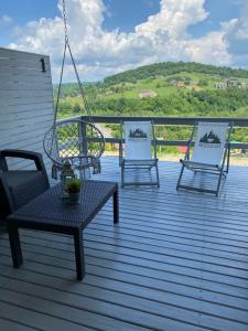 three chairs and a table on a deck with a view at Amaretto Apartamenty-Solina in Solina