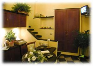 una oficina con un escritorio con flores. en Camere D'Autore La Poesia en Monterosso al Mare