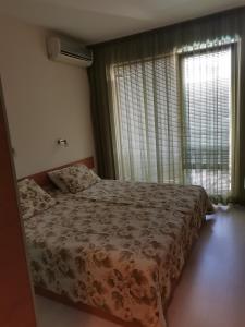 a bedroom with a bed and a large window at Апартамент Весела-Хоризонт in Sozopol