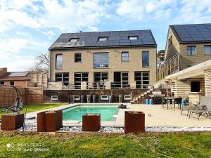 a house with a swimming pool in front of it at Appartement 5 personnes avec accès piscine in Thyle