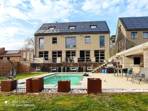 een huis met een zwembad ervoor bij Appartement 5 personnes avec accès piscine in Thyle