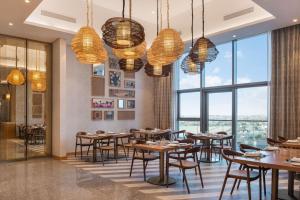 een restaurant met tafels en stoelen en grote ramen bij Paramount midtown residence luxury 3 bedroom with amazing sea view and close to burj khalifa and dubai mall in Dubai