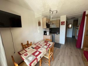 uma cozinha e sala de jantar com uma mesa e uma televisão em Grand Studio em Les Carroz d'Arâches