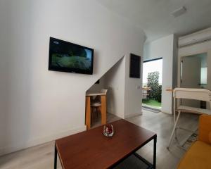 a living room with a table and a tv on the wall at Apartamento moderno y acogedor. in Almería