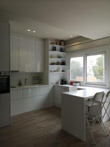 a kitchen with white cabinets and a table and a window at Riviera Studio in Athens