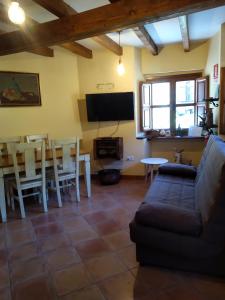 a living room with a couch and a table and a tv at Casa Llayo in Aliezo