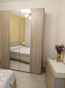 a bedroom with two beds and a mirror at In Centro - Noto in Noto +2 photos