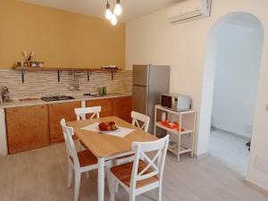 a kitchen with a table with chairs and a refrigerator at In Centro - Noto in Noto