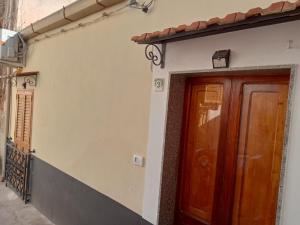 a house with a wooden door on the side of it at In Centro - Noto in Noto