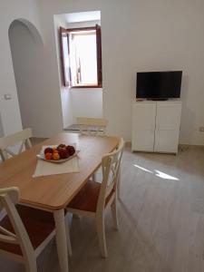 a dining room table with a bowl of fruit on it at In Centro - Noto in Noto