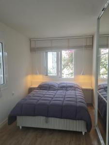 a bedroom with a large bed and two windows at Riviera Studio in Athens