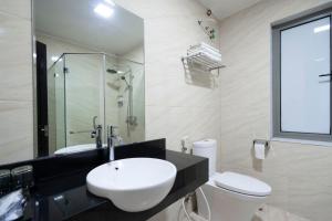 baño con lavabo y aseo y ventana en LUXURY HOTEL, en Ha Long