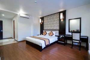a bedroom with a bed and a desk and a mirror at LUXURY HOTEL in Ha Long