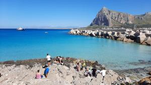 un gruppo di persone su una spiaggia rocciosa di Casa Vacanze San Vito Lo Capo a San Vito lo Capo