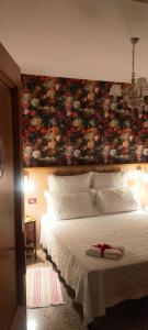 B&B L'Albero Di Antonia في أدري: غرفة نوم بسرير كبير وبجدار ورد