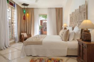 Un dormitorio con una gran cama blanca y una ventana en Riad Alma, en Marrakech
