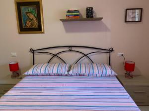 a bedroom with a bed with a striped comforter at La Casetta in Verona