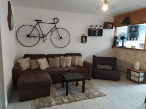 uma sala de estar com um sofá e uma bicicleta pendurada na parede em Joli appartement avec grande et belle terrasse, au pied de la plage du Grazel! em Gruissan